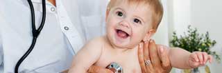 Smiling baby being examined by a doctor