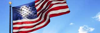 American flag waving in the wing against a bright blue sky