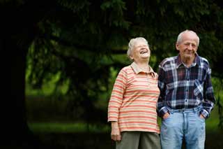 Elderly woman and man laughing together in the park