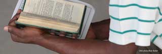 A young African-American man reads the Bible