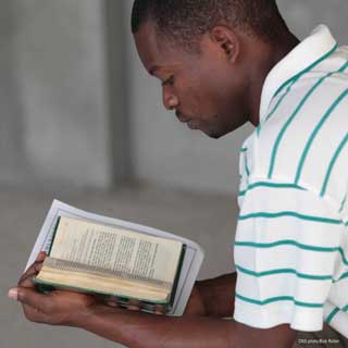 A young African-American man reads the Bible