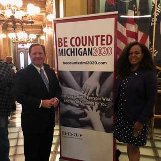 MCC President and CEO Paul Long and Michigan Nonprofit Association President and CEO Donna Murray Brown stand next to a Be Counted Michigan 2020 banner at the State Capitol Building
