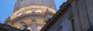 A up-close view of the Michigan State Capitol building dome from the ground.