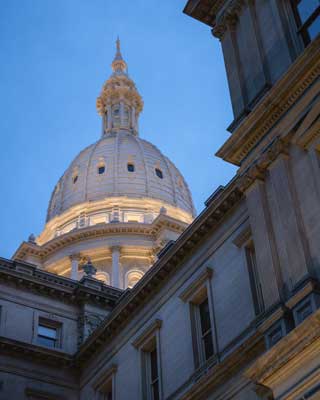 A up-close view of the Michigan State Capitol building dome from the ground.