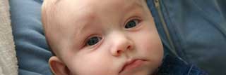 A baby boy staring at the viewer.