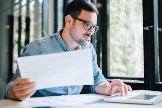 A professional attending a webinar while looking through paperwork