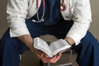 A doctor reading the Bible.
