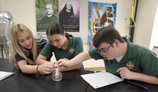 St. Mary Catholic Central (SMCC) sophomores (from left) Avery Towne, Paxton Ball, and Gavin O’Kelley work together on a science experiment. O’Kelley is a member of the St. Andre Bessette Open Doors Inclusion program for SMCC students with special learning needs. Photo by Tom Hawley, Monroe News.