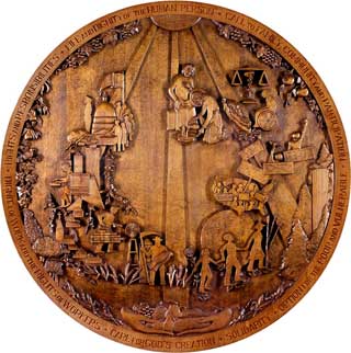 Photo: A wood carving by Pierre Bataille depicting the seven principles of Catholic social teaching. Displayed in the Michigan Catholic Conference lobby, its location reflects the integral role these principles play in MCC's work.
