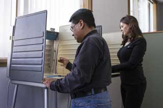 A man and a woman both exercising their right to vote