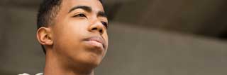 A teenager stares wistfully into the distance, thinking about his future