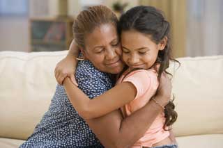 A young girl hugs her grandmother affectionately