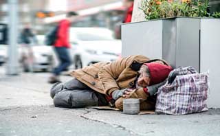 A destitute man sleeping on the sidewalk