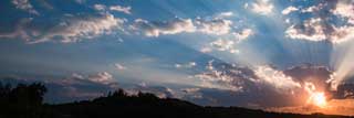 The sun rising from behind a cloud