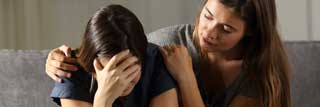 A woman comforts her friend