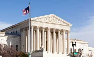 The flag of the United States flying over The Supreme Court building in Washington, DC