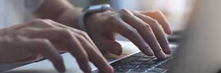 Closeup of a woman's hands as she writes an email urging her U.S Representative to oppose the Women's Health Protection Act (HR 3755)