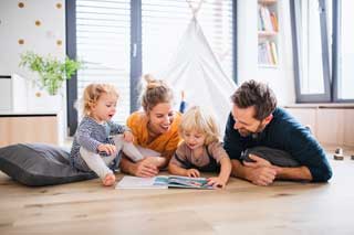 A young family reading together on the floor