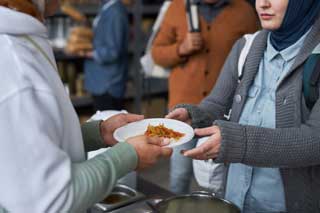 A person receiving food in a soup kitchen.