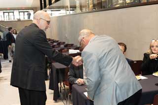 Bishop John Doerfler of the Diocese of Marquette shakes hands with Sen. Joe Bellino Jr. (R-Monroe).