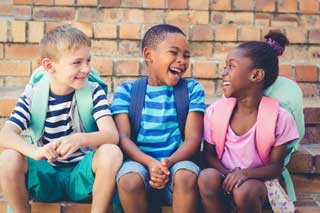 Three laughing school children
