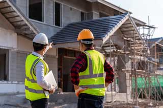 Two construction workers preparing to work on a building